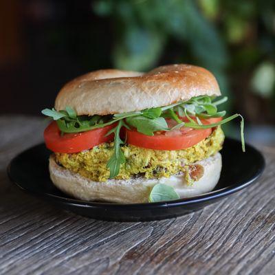 Curry Chicken Salad Sandwich - Bagel of choice with hearty scoop of curry seasoned, autumn berry chicken salad, topped w/ tomato and arugula