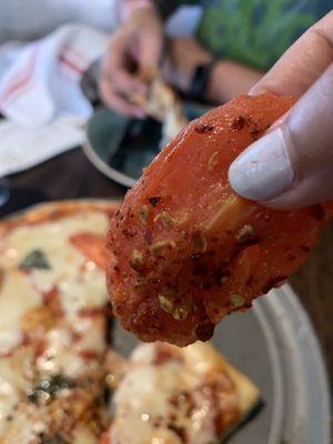 Big chunks of raw tomato kept on the top of margarita pizza