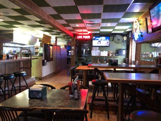 High top tables at the front of the restaurant with a bar to the left and Live Poker straight ahead.