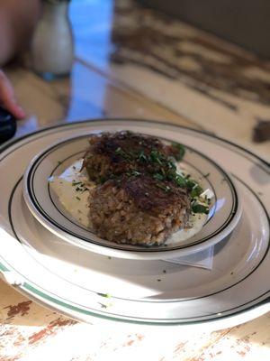 Pan-seared boudin cakes on a bed of ranch dressing.