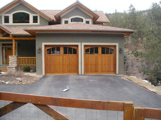 Garage doors for mountain house in Colorado. Rustic wood doors with arched windows.