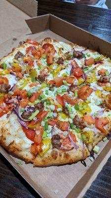 Los Banos: White Garlic Sauce, Minced Garlic, Pepperoni, Sausage, Red & Green Onion, Tomatoes & Peperoncini.