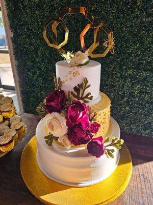 Three-tiered wedding cake. topper was red velvet, middle was carrot cake and bottom layer was vanilla tres leches cake!