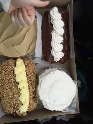 Two long johns, a maple glazed cinnamon roll, and a blueberry and cream cheese filled.