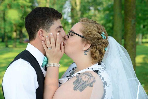 Bride and groom share a tender moment of an intimate kiss