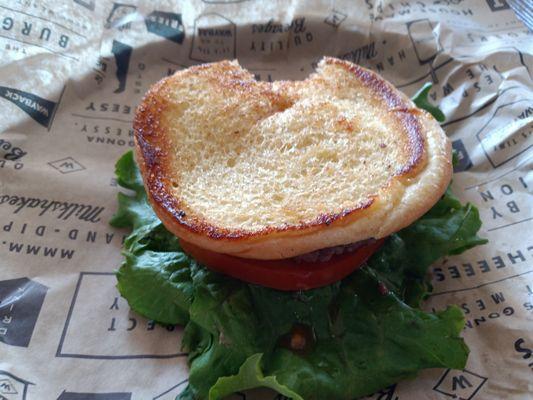 Grilled hamburger with grilled onions, lettuce, tomato.