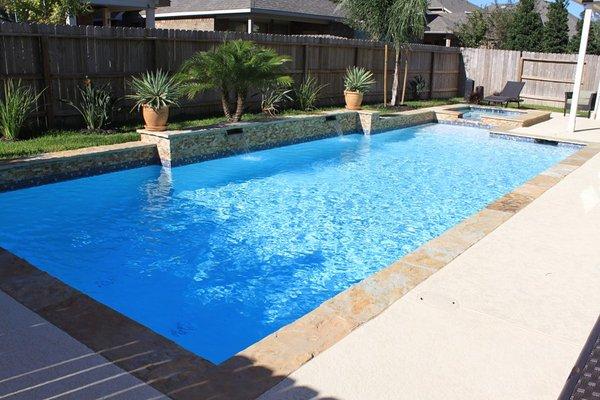 Rectangular pool with stone retaining wall with water features