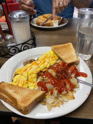 Eggs, corned beef hash, breakfast potatoes, and toast