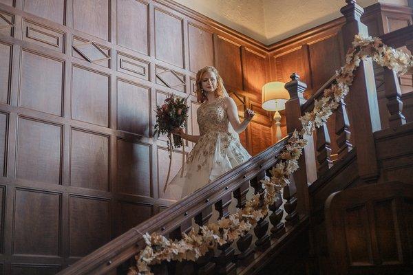 Fall November bride walking down staircase with wedding bouquet in vintage victorian Stoneleigh estate, Virginia mountains, anomalie dress