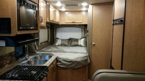 Interior of 2018 Thor Chateau 24' RV. Rear queen bed, full bath and kitchen.