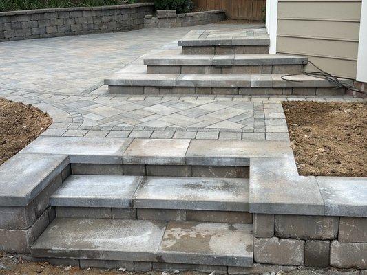 Steps up to patio and into kitchen entrance. Small garden area underneath kitchen window.