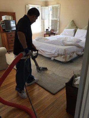 Raul cleaning an area rug.