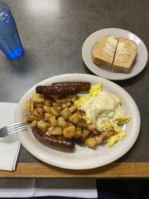 Soft scrambled eggs with cheese, home fries, and sausage with wheat toast.