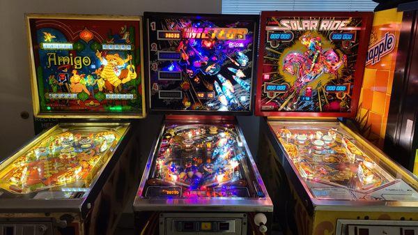 Pinball machines outside of the bathrooms.