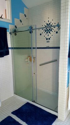 Bathroom remodel with frame-less glass sliding doors. Tiled both shower area along with adjacent wall.