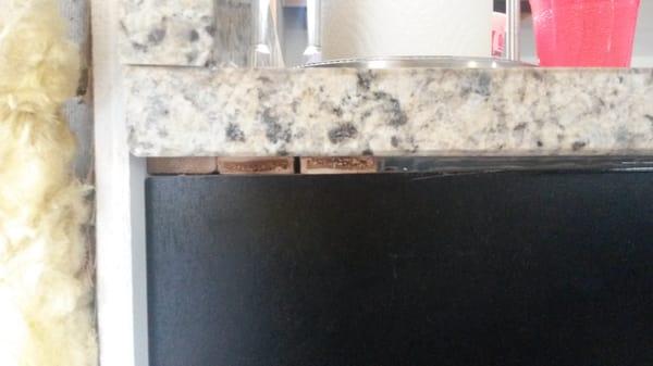 They brought two different thicknesses of granite and shimmed the end to make the two pieces seem to meet