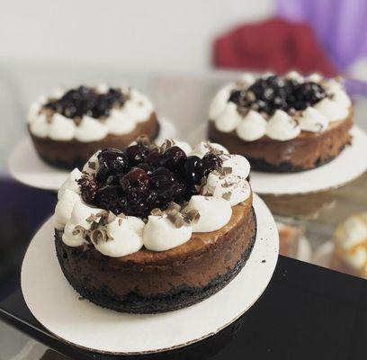 Black Forest Cheesecake. Chocolate cookie crust, Chocolate cheesecake filling, cherry compote, chantilly cream, chocolate curls.