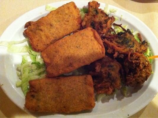 Appetizers. Vegetable pakora on the right. The rectangle items are a fried paneer.