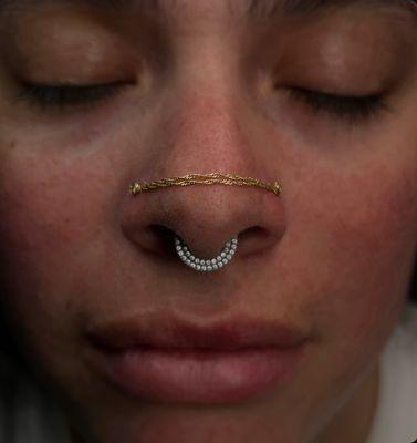 14 karat gold nostril chain connecting these two nostril piercings