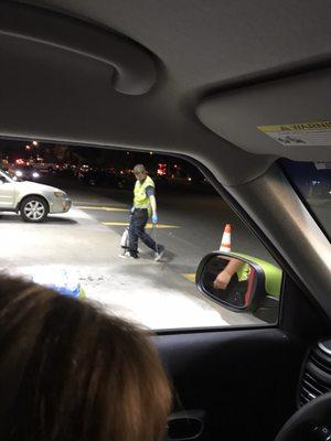 Spraying something all over the ground while here's 3-4 cars deep behind the pumps waiting to get gas.