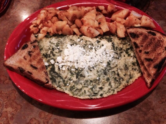 Spinach and feta omelette with home fries and cinnamon raisin toast.