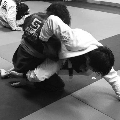 A student successfully hitting the hip bump sweep on his partner during the drilling portion of BJJ Basics class.