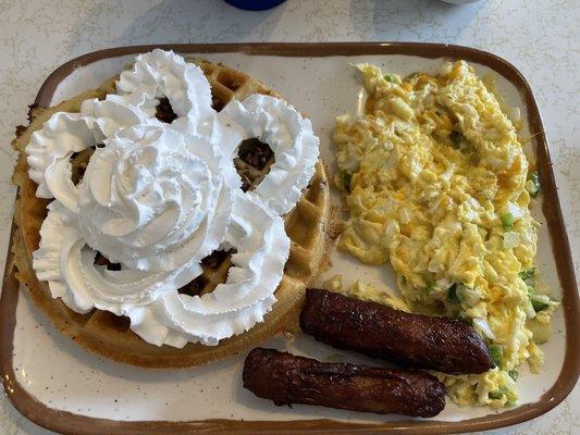 Pecan Belgian waffle, scrambled eggs with cheese, green peppers and onions and sausage links.