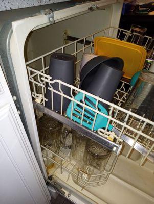 The dishwasher is not mounted and falling out of the wall.