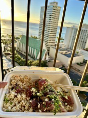 Enjoying Off the Hook Poke bowl with beautiful view of Waikiki beach during sunset