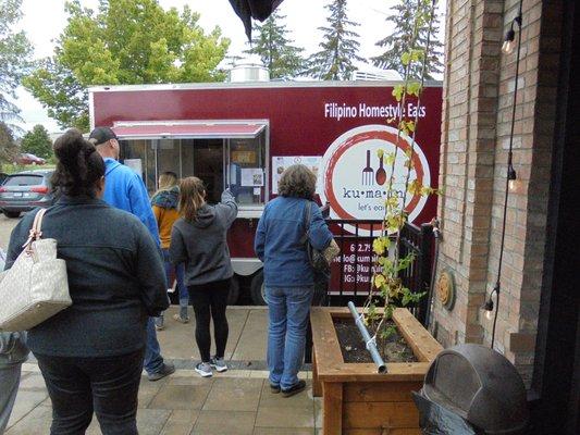 Customers lining up at the food trailer on a cold rainy day - great food!