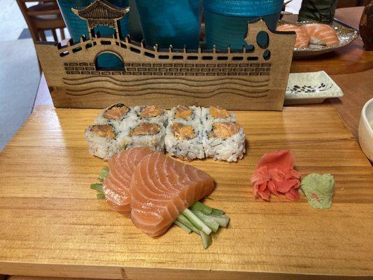 Two pieces of salmon sashimi and a spicy salmon roll.