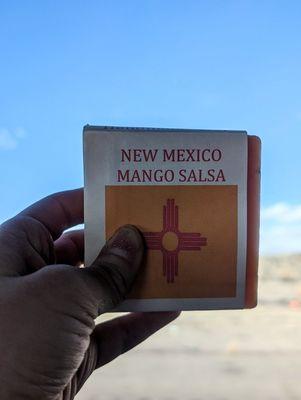 The front of Lillie's Handmade Soaps' New Mexico Mango Salsa bar soap ft. New Mexico scenery & cornflower sky in the background