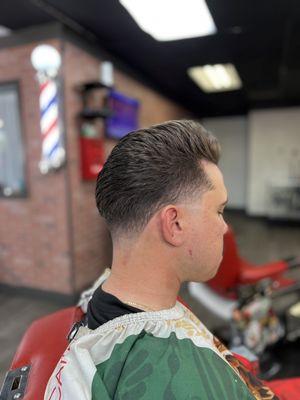 Slick back pompadour with skin tapers done by Phez the barber.