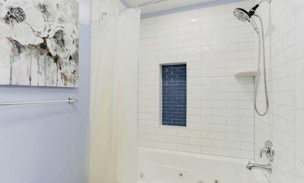 Jacuzzi bath with recessed tile shelf and corner ceramic shelving