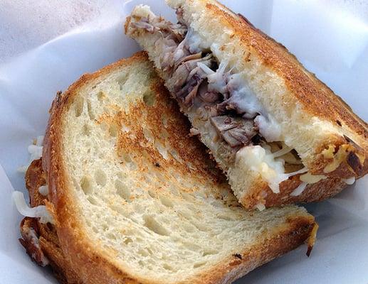 "Duck Confit Grilled Cheese" from Devilicious: shredded duck confit, gruyere and mozzarella cheeses and honey port reduction on sourdough.