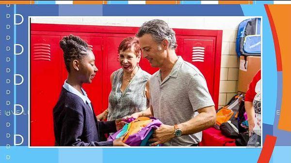 Mike provides a student with a backpack for their annual Project Backpack