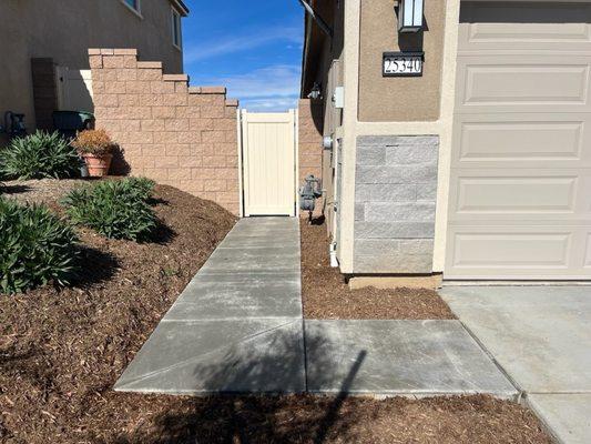 Concrete from garage/side yard extended to driveway to make trash roll out easy