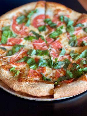 The Margarita - crispy crust lightly brushed with olive oil and topped with mozzarella, parmesan, tomato, and basil!