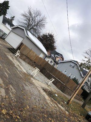 Back of property retaining wall and new concrete slab that they poured.