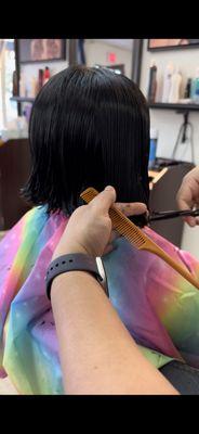 Hairstylist in action for bob cut hairstyle.