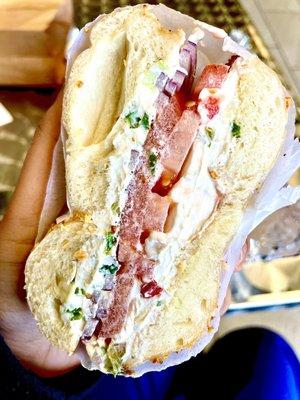 Onion bagel lightly toasted with light butter, vegetable cream cheese tomatoes, onions salt and pepper