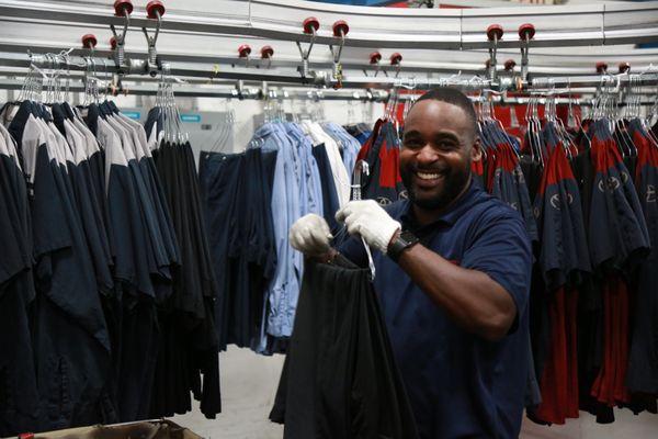 Route Service Rep, Travion, prepping garments for his customers.