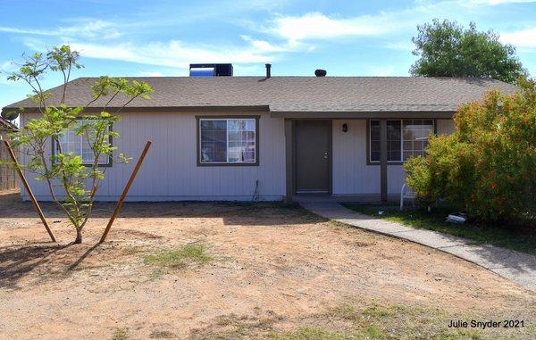 After photo of house with new paint, siding and new door. Repairs made to facia.