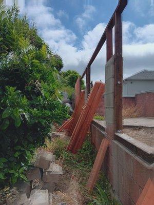 Wood fence being rebuilt framing, 2x4s and 4x4s & bolts securing  the fence framing.