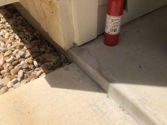 Sloppy underpinning and concrete work causes water to collect at back porch