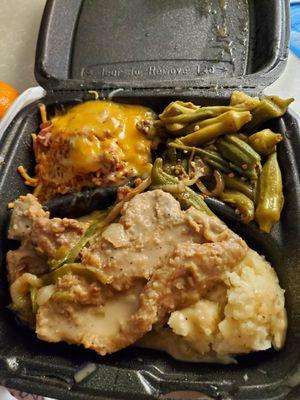 Smothered pork chops with mashed potatoes, okra and bbq spaghetti