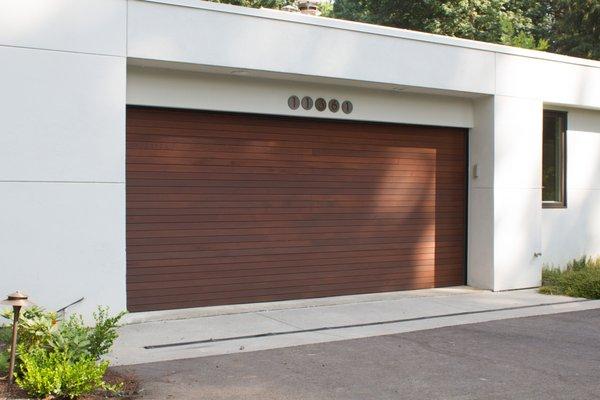 A modern flush door sided with custom material to match the home.