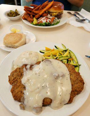 Chicken fried steak with mashed potatoes and vegetables.