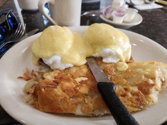 Traditional eggs benedict with ham and home fried potatoes.