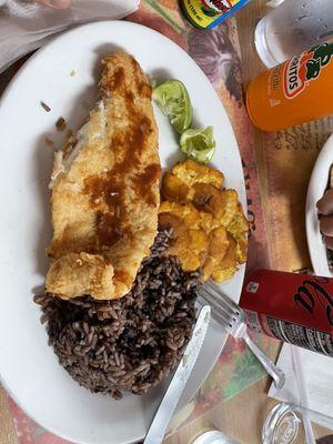 Fried fish filet, beans and rice and smashed green plantains